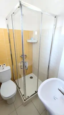 a bathroom with a shower and a toilet and a sink at Residencial Amarante in Mindelo