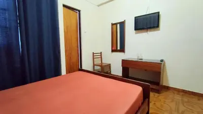 a bedroom with a bed and a desk and a television at Residencial Amarante in Mindelo