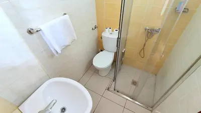 a bathroom with a shower and a toilet and a sink at Residencial Amarante in Mindelo