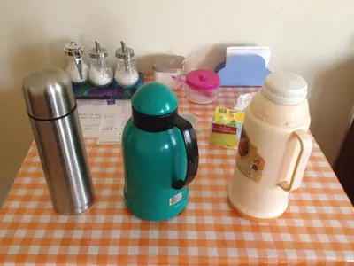 a table with a green coffee maker and a thermos at Sissi's B&B in Ponta do Sol