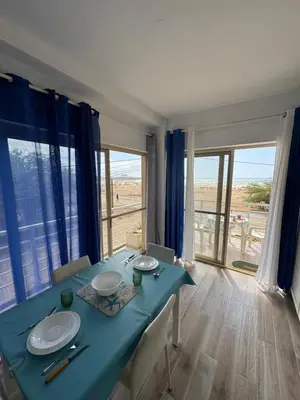 a dining room with a blue table and a view of the beach at KA ANGELA, WI-FI FREE Praia Cabral, Sal Rei in Sal Rei