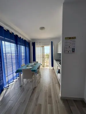 a dining room with a green table and blue curtains at KA ANGELA, WI-FI FREE Praia Cabral, Sal Rei in Sal Rei