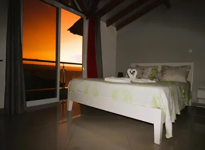 a white bed in a room with a window at Dunas De Areia Preta in Ribeira da Prata
