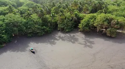 an aerial view of a beach with a boat in the water at Dunas De Areia Preta in Ribeira da Prata