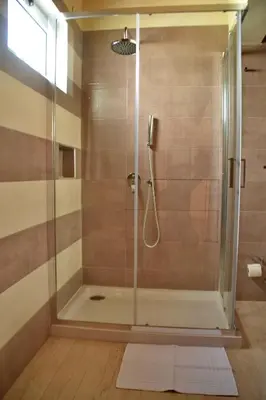 a shower with a glass door in a bathroom at Ouril Hotel Julia in Santa Maria