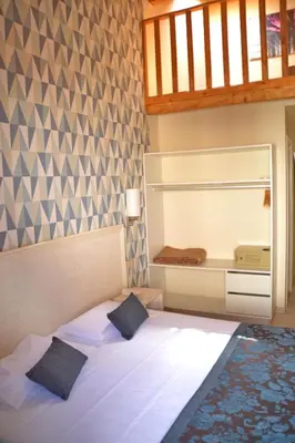 a bedroom with a bed with two pillows at Ouril Hotel Julia in Santa Maria