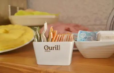 a cup of carrots and other food items on a table at Ouril Hotel Julia in Santa Maria