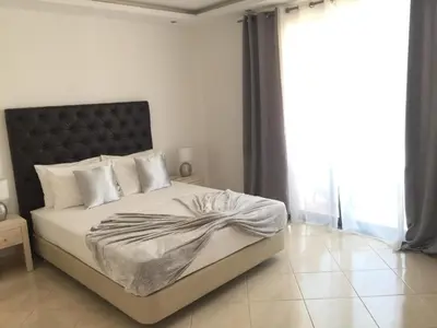 a bedroom with a large bed with a black headboard at Lali's House in Tarrafal