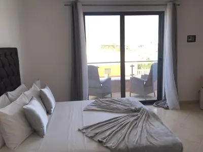 a bedroom with a bed with a view of a balcony at Lali's House in Tarrafal