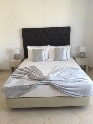 a bedroom with a large bed with a black headboard at Lali's House in Tarrafal