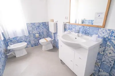 a blue and white bathroom with a sink and a toilet at Halos Casa Resort in Santa Maria