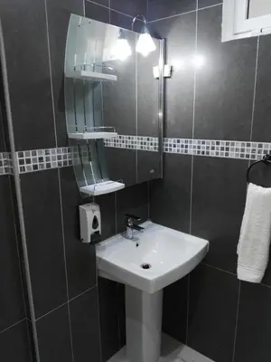 a bathroom with a sink and a mirror at Residencial Casa da Luz in Mindelo