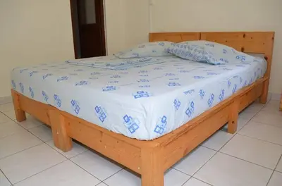 a bed with a wooden frame in a room at casa xoxo in Ribeira Grande