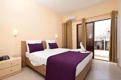 a hotel room with a large bed and a window at Aparthotel Praiano in Praia