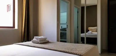 a bedroom with a bed with two towels on it at Aparthotel Praiano in Praia