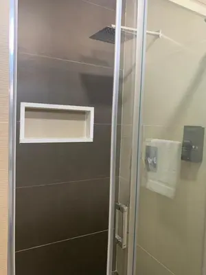 a shower with a glass door in a bathroom at Aparthotel Praiano in Praia