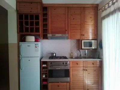 a kitchen with wooden cabinets and a white refrigerator at Solmar apartment in Beirona