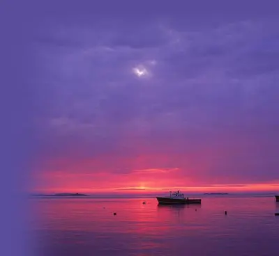 a boat in the water with a sunset at Solmar apartment in Beirona