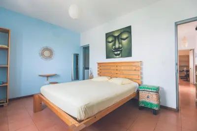 a bedroom with a bed with a painting on the wall at Casa Tabanka Apartment in Tarrafal