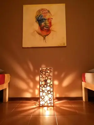 a lighted lamp in a living room with a painting at Casa Tabanka Apartment in Tarrafal
