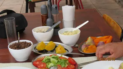 a wooden table with bowls of food on it at Casa Branca in Porto Novo