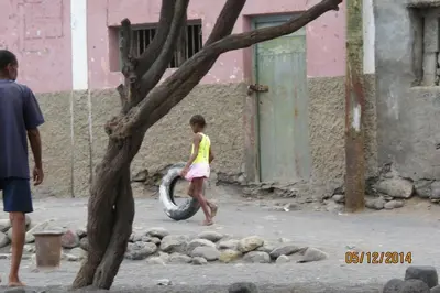 a little girl playing with a tire in a tree at Casa Branca in Porto Novo