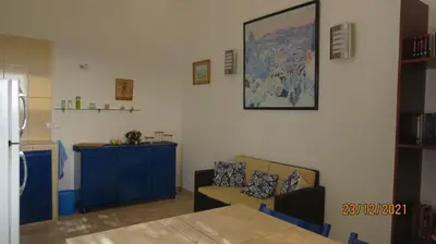 a kitchen with a table and a blue cabinet at Casa Branca in Porto Novo