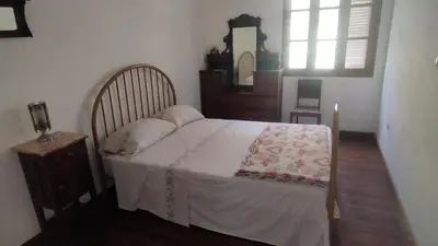 a bedroom with a bed with a table and a window at Wahnon Guesthouse in Paul
