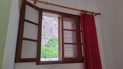 a window with a red curtain in a room at Wahnon Guesthouse in Paul