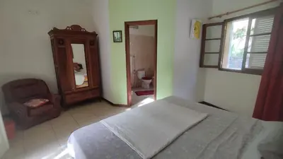 a bedroom with a bed and a chair and a mirror at Wahnon Guesthouse in Paul