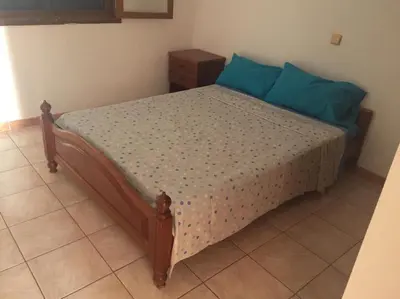 a bedroom with a bed with blue pillows at bed & breakfast Regina in Tarrafal