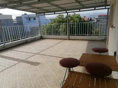 a balcony with two chairs and a bench on it at Casa Cabral : Big Apartment next to the beach in Tarrafal