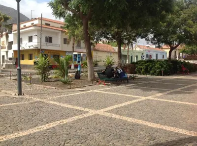 two people sitting on a bench in a park at Casa Cabral : Big Apartment next to the beach in Tarrafal