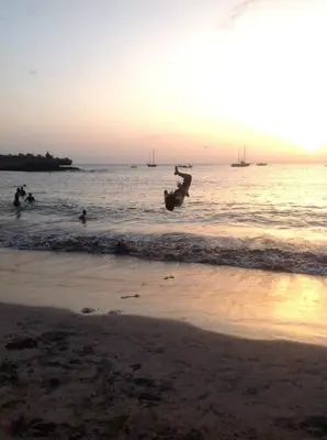 a person jumping into the water at the beach at Casa Cabral : Big Apartment next to the beach in Tarrafal