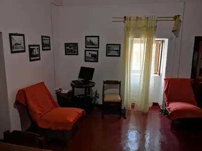 a living room with two chairs and a computer on the wall at Kaza Ladera in Seladinha