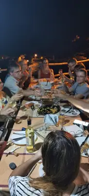 a group of people sitting around a long table at Kaza Ladera in Seladinha