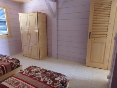 a room with two beds and a closet and a door at Casa Madeira in Porto Novo