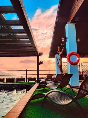 a group of chairs sitting next to a swimming pool at Hotel Belvedere Mindelo, Cabo Verde in Mindelo
