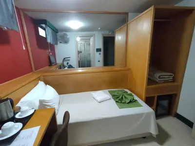 a small bedroom with a bed with a mirror at Hotel Belvedere Mindelo, Cabo Verde in Mindelo