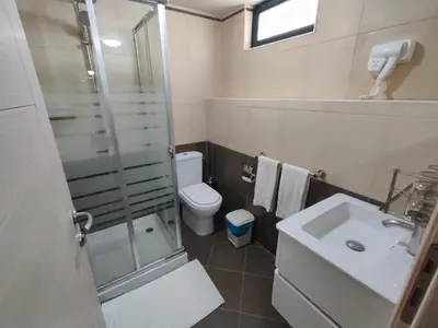 a bathroom with a shower and a toilet and a sink at Hotel Belvedere Mindelo, Cabo Verde in Mindelo