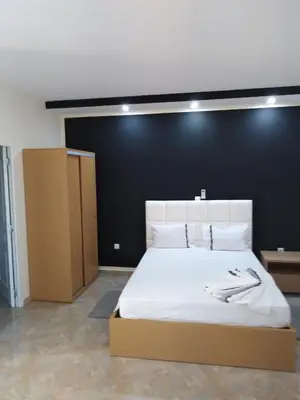 a bedroom with a large white bed with a black wall at Residêncial Carlos Carvalho in Praia
