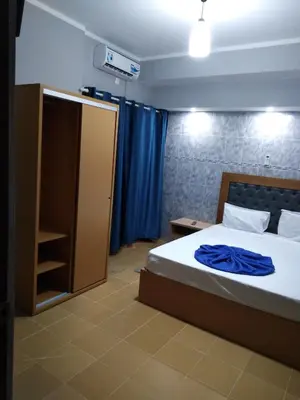 a bedroom with a bed with a blue blanket on it at Residêncial Carlos Carvalho in Praia