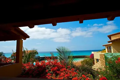 a view of the beach from a house with flowers at Porto Antigo Top 10 in Santa Maria
