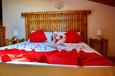 a large bed with red and white blankets and pillows at Porto Antigo Top 10 in Santa Maria