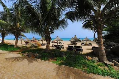 a beach with chairs and umbrellas and the ocean at Porto Antigo Top 10 in Santa Maria