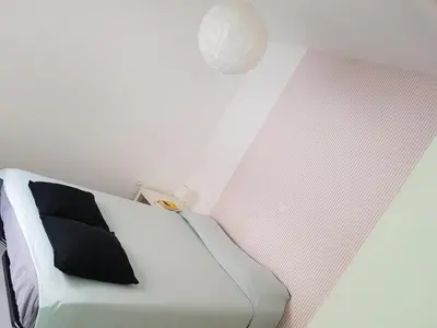 a bedroom with a white bed with a black pillow at Casa Io - Djeu in Mindelo