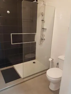 a bathroom with a toilet and a glass shower at Casa Io - Djeu in Mindelo