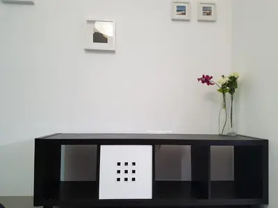 a black table with a vase of flowers on it at Casa Io - Djeu in Mindelo