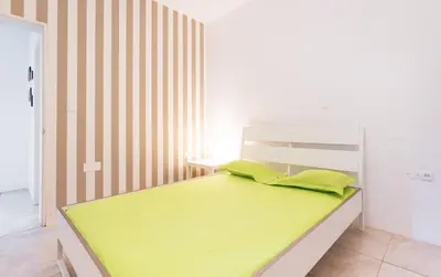 a bedroom with a bed with lime green sheets at Casa Io - Bica in Mindelo