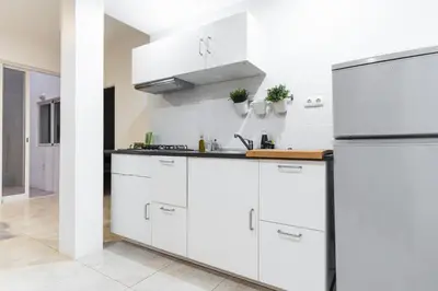 a kitchen with white cabinets and a refrigerator at Casa Io - Bica in Mindelo